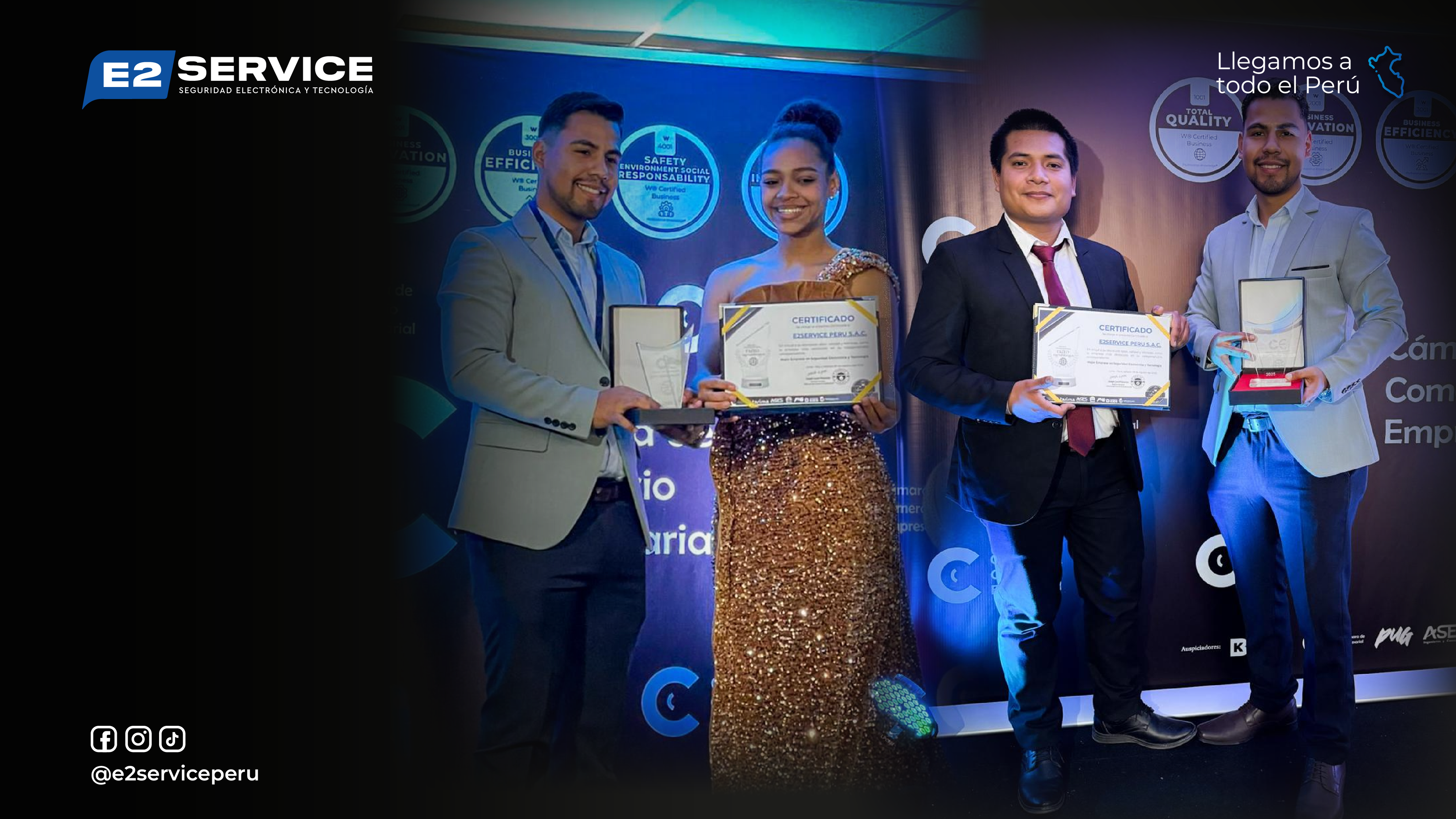 Fondo de personas vestidas elegantemente sosteniendo diplomas y premios en un escenario con iluminación azul y negro, destacando una ceremonia formal de premios.